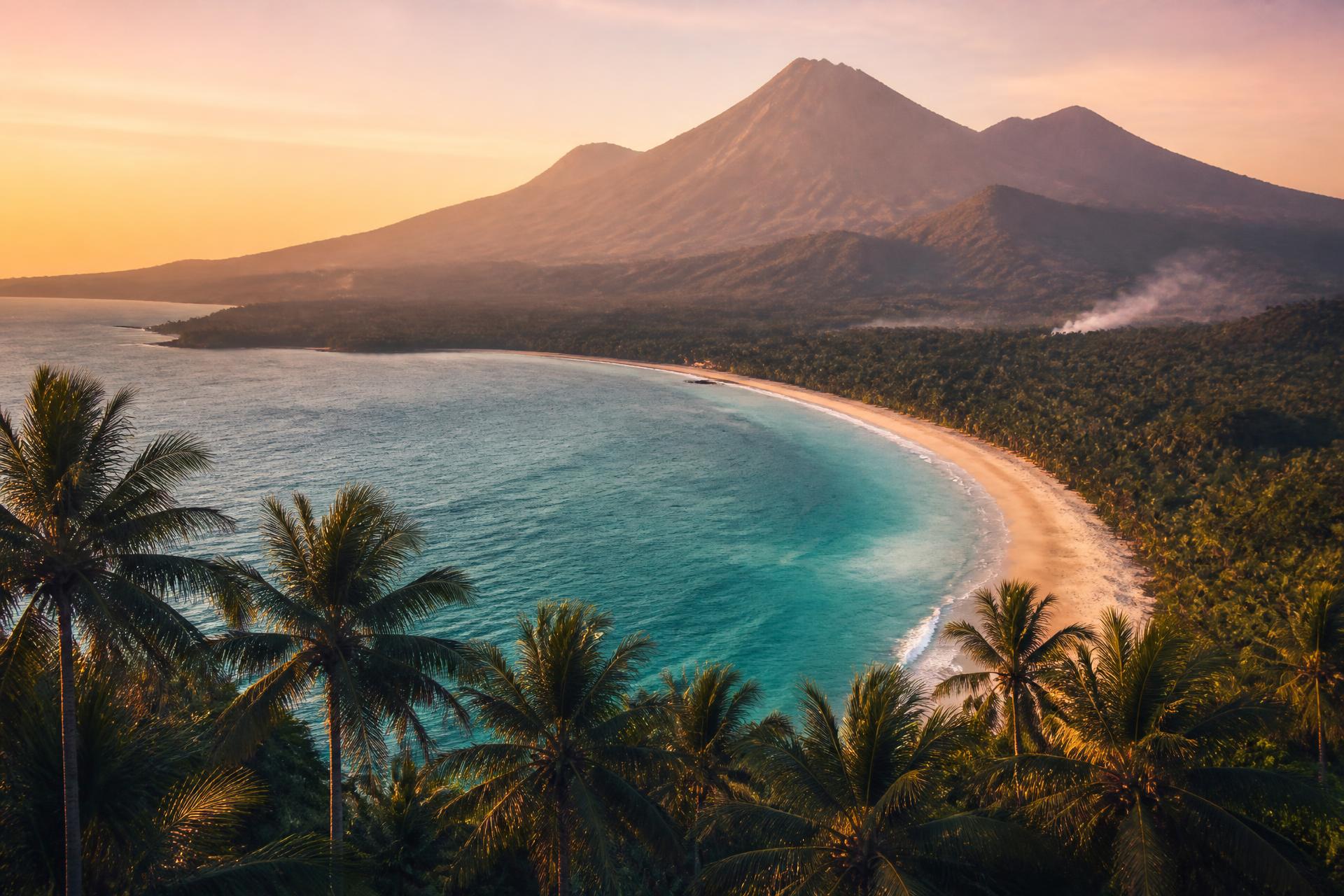Bucht auf Lombok mit Palmen und dem Vulkan Rinjani im Morgenlicht